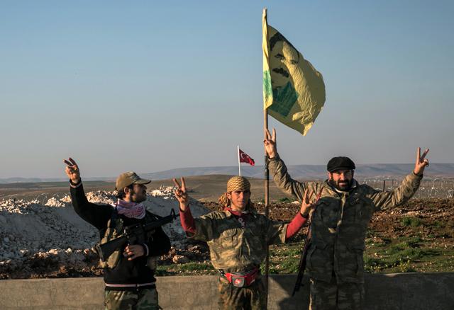 In this Feb. 22, 2015, file photo, Syrian Kurdish militia members of the YPG make a V-sign next to a drawdng of Abdullah Ocalan, jailed Kurdish rebel leader, in Esme village in Aleppo province, Syria. (AP) In this Feb. 22, 2015, file photo, Syrian Kurdish militia members of the YPG make a V-sign next to a drawdng of Abdullah Ocalan, jailed Kurdish rebel leader, in Esme village in Aleppo province, Syria. (AP)