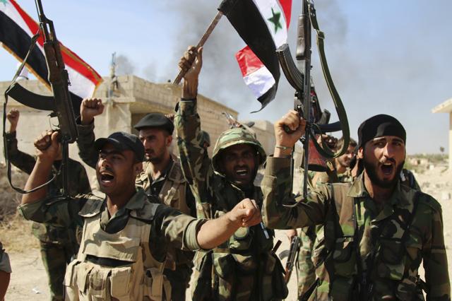 In this photo taken on Sunday, Oct. 11, 2015, Syrian soldiers waving Syrian flags celebrate the capture of Achan, Hama province, Syria. Russian jets intensified their airstrikes Monday in the central Syrian province as government and allied troops pushed out insurgents from local villages to expand their control of the area, activists and a military statement said. (AP) In this photo taken on Sunday, Oct. 11, 2015, Syrian soldiers waving Syrian flags celebrate the capture of Achan, Hama province, Syria. Russian jets intensified their airstrikes Monday in the central Syrian province as government and allied troops pushed out insurgents from local villages to expand their control of the area, activists and a military statement said. (AP)