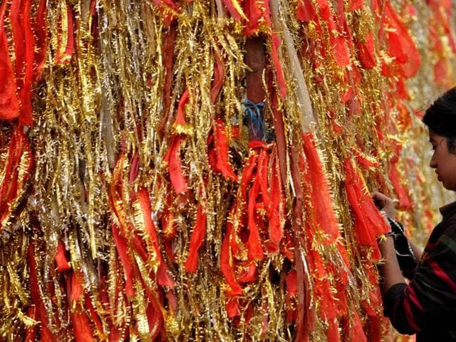 A devotee tying a religious piece of cloth on the first day of Navratras at a temple in Jammu on Tuesday. (Nitin Kanotra / HT)