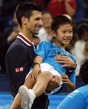 Novak Djokovic of Serbia picks up a child during a photo call on court after winning his match against Martin Klizan of Slovakia. (AFP Photo) Novak Djokovic of Serbia picks up a child during a photo call on court after winning his match against Martin Klizan of Slovakia. (AFP Photo)
