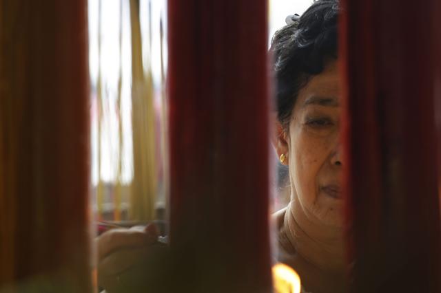 A Thai woman holds incense sticks during prayer at Thian Fah Chinese temple in Bangkok. (AP)