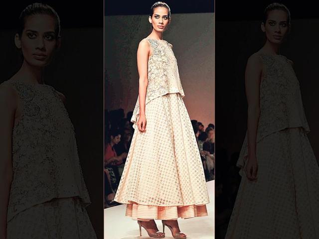 This is a classy take by designer Kavita Bhartia. The asymmetrical blouse with subtle bling over a double-layered skirt is perfect for a day event. The play with different fabrics for the lehenga takes the look up a notch. (Text- Aditi Caroli)
