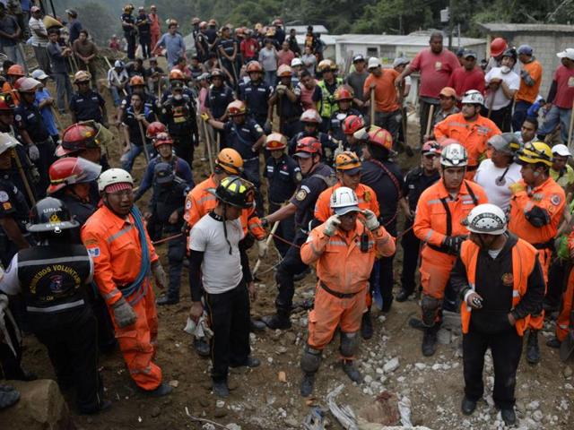 Firemen, rescuers, and volunteers take part in the rescue operations after a landslide late Thursday, following heavy rains, covered part of the village of El Cambray II, in Santa Catarina Pinula municipality, some 15 km east of Guatemala City, on October 2, 2015. (AFP Photo)