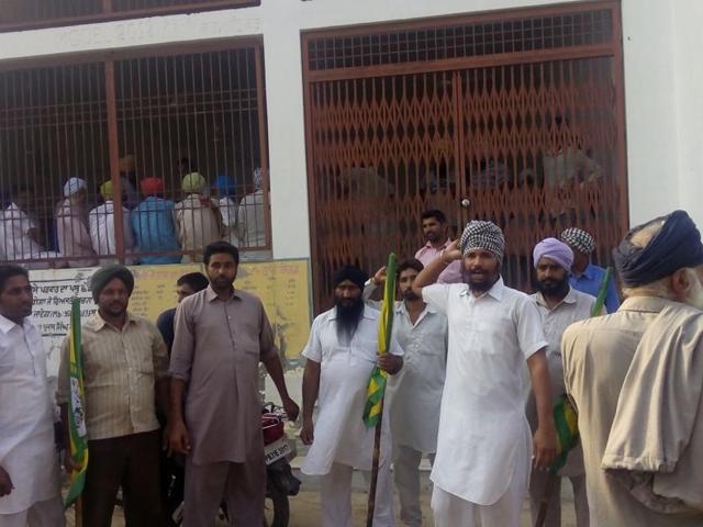 Farmers staging a protest outside the panchayat office where two Akali leaders were locked for two hours at Gobindpura village in Mansa district on Friday.(HT Photo)