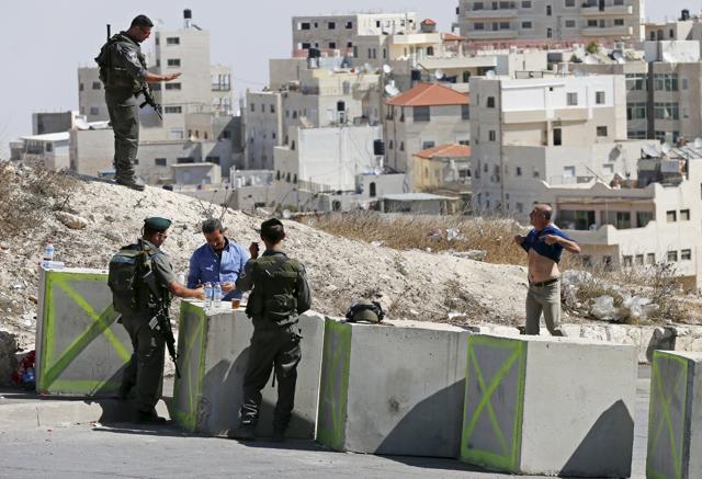 A Palestinian man pulls up his shirt during a security check by Israeli paramilitary border policemen at a roadblock, set-up by Israel this week in an effort to stop a wave of Palestinian knife attacks, in the East Jerusalem neighbourhood of Issawiya. (REUTERS) A Palestinian man pulls up his shirt during a security check by Israeli paramilitary border policemen at a roadblock, set-up by Israel this week in an effort to stop a wave of Palestinian knife attacks, in the East Jerusalem neighbourhood of Issawiya. (REUTERS)