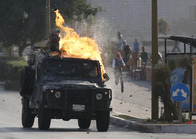 An Israeli security forces jeep ignites as Palestinian protesters throw a Molotove cocktail at it during clashes near the Beit El settlement on the outskirts of Ramallah. (AFP) An Israeli security forces jeep ignites as Palestinian protesters throw a Molotove cocktail at it during clashes near the Beit El settlement on the outskirts of Ramallah. (AFP)