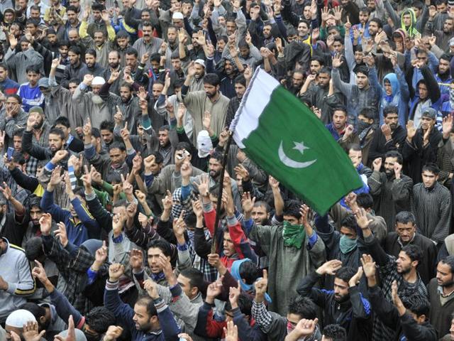 A youngster carries Pakistani flag as others shout pro-freedom slogans during the funeral procession of Udhampur truck attack victim. (Waseem Andrabi/HT)