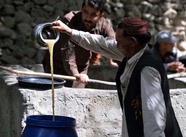 A local resident pours the juice from crushed grapes as part of a brewing wine process in a garden. (AFP) A local resident pours the juice from crushed grapes as part of a brewing wine process in a garden. (AFP)