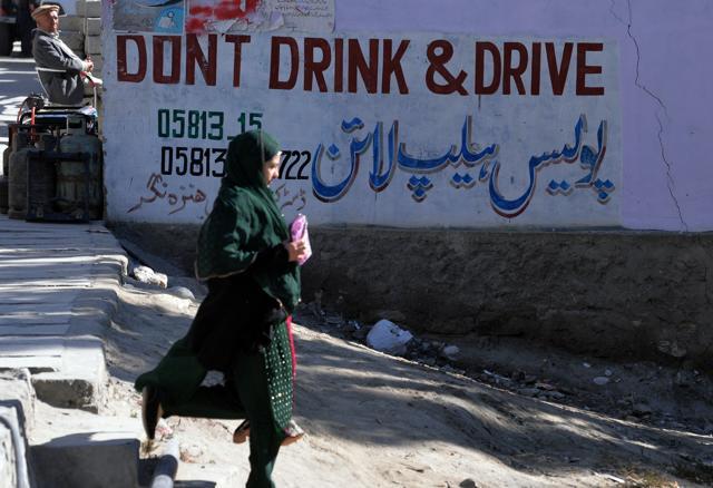 A woman walks past a sign pasted by authorities that says “Dont Drink and Drive” along the Karakoram Highway at Aliabad in the Hunza Valley in northern Pakistan. (AFP) A woman walks past a sign pasted by authorities that says “Dont Drink and Drive” along the Karakoram Highway at Aliabad in the Hunza Valley in northern Pakistan. (AFP)