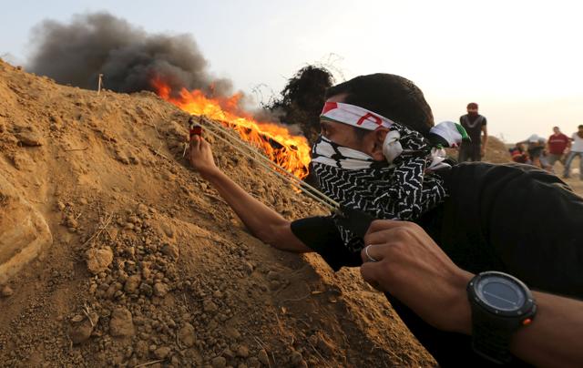 A Palestinian protester uses a slingshot to hurl stones towards Israeli troops during clashes near the border between Israel and Central Gaza Strip October. Forty-one Palestinians and seven Israelis have died in recent street violence, which was in part triggered by Palestinians' anger over what they see as increased Jewish encroachment on Jerusalem's al-Aqsa mosque compound. (REUTERS Photo)