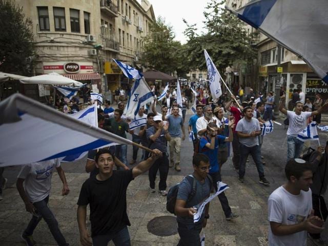 People sing and dance with Israeli national flags at a pedestrian street in downtown Jerusalem. (Reuters Photo)