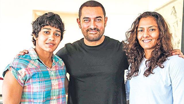 Aamir Khan (centre) with Babita (left) and Geeta Phoghat (right). (Getty Images)