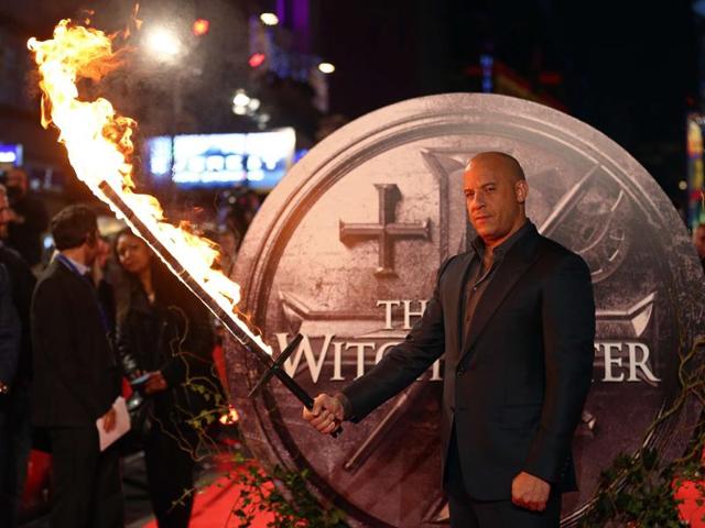 US actor Vin Diesel holds a flaming sword as he arrives on the red carpet to attend the European premiere of the film The Last Witch Hunter. (AFP)