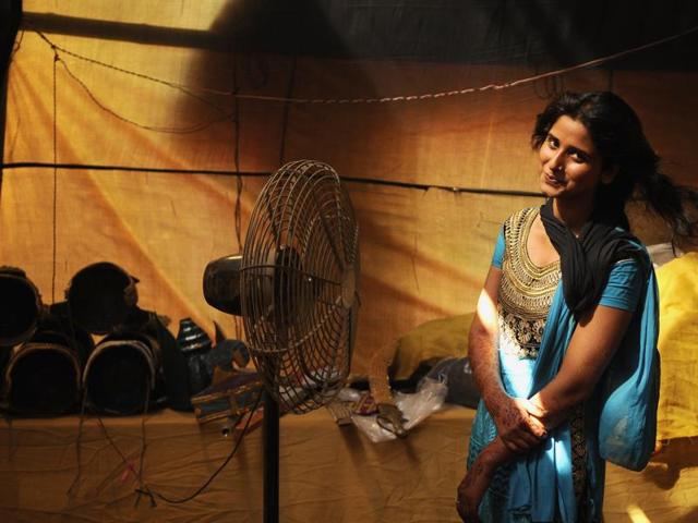 Farhana Khan, who plays the role of Sita in Ramlila, waits for her turn to get ready for the stage in Greater Noida. (Burhaan Kinu/HT Photo)