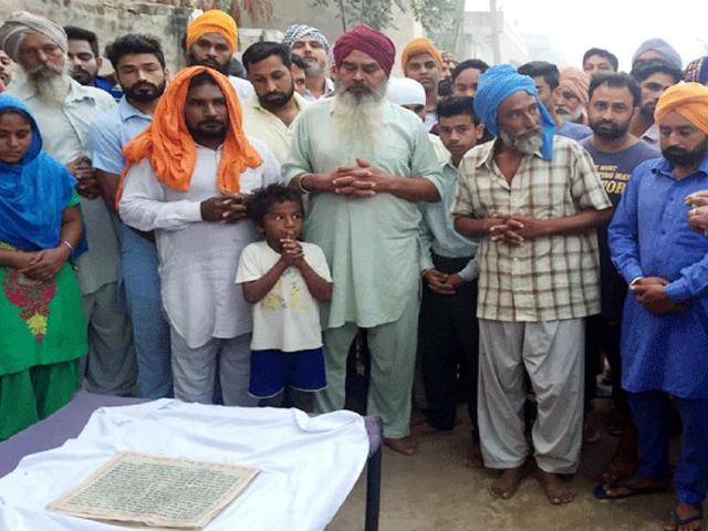 Villagers praying after the desecration incident at Gurusar village in Bathinda district on Tuesday.(Sanjeev Kumar/HT)