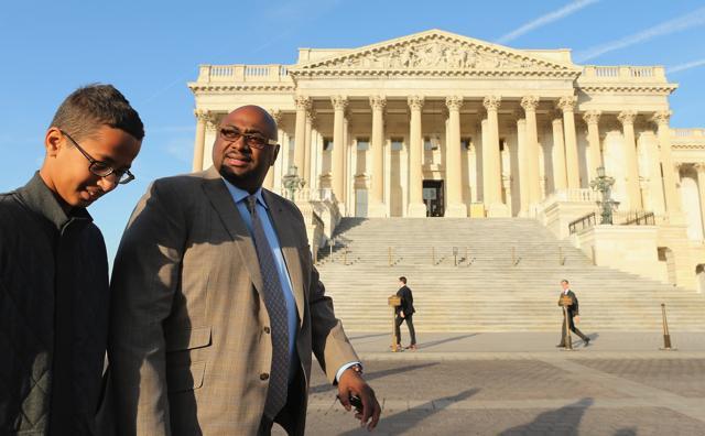 Fourteen-year-old Ahmed Mohamed (C) of Irving, is guided by family advisor and former Dallas Independent School District Trustee Ron Price after a news conference outside the US Capitol in Washington DC. Mohamed was arrested by police last month when he brought a home-made electronic clock to class at MacArthur High School and officials mistook it for a bomb. (AFP Photo)