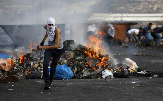 A Palestinian protester clashes with Israeli security forces (unseen) in the West Bank town of Al-Bireh, on the northern outskirts of Ramallah, on October 20, 2015. (AFP Photo)
