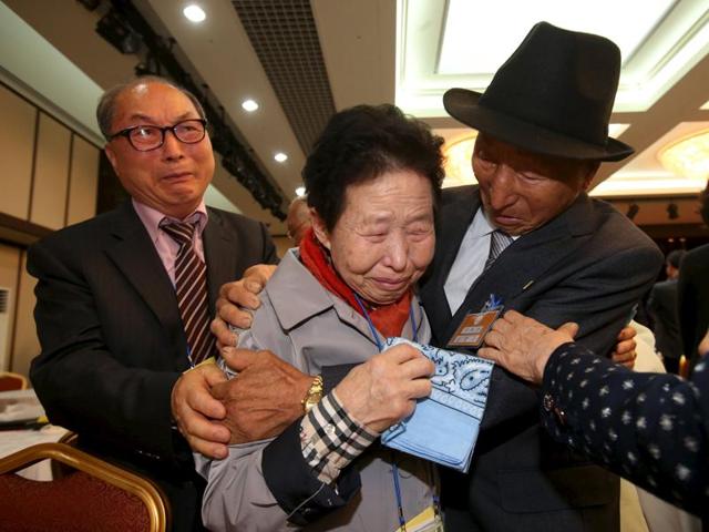 South Korean Lee Jin-goo (C) meets her North Korean brother Lee Yong Goo (R) during the separated family reunions at Mount Kumgang resort, North Korea. In an outpouring of emotions and tears, nearly 400 South Koreans crossed the heavily armed border into North Korea to be reunited with family members separated for more than six decades since the 1950-53 Korean War. (Reuters Photo)
