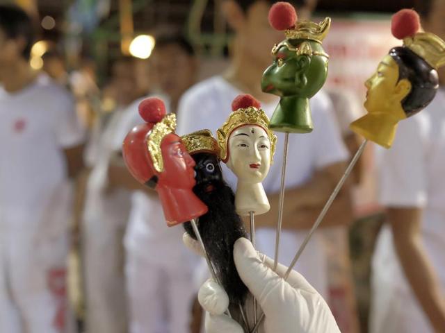 Chinese emperor gods spikes are displayed outside the Chinese shrine of Ban Tha Rue in Phuket. The Vegetarian Festival begins on the eve of the ninth lunar month of the Chinese calendar and is observed primarily in Southeast Asian countries, including Thailand, Malaysia, Singapore and Myanmar.. (AP Photo/David Longstreath) (AP)
