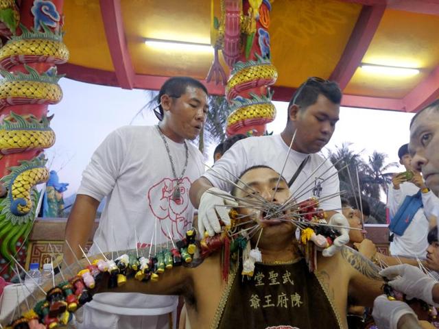 A devotee to the Chinese shrine of Ban Tha Rue has his face and arms pierced prior to a street procession. The festival is believed to bestow good fortune on those who practice the religious rites. (AP Photo/David Longstreath) (AP)