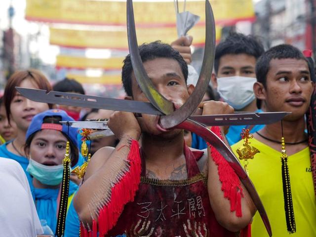 Men and women devotees during the festival work themselves into trances to have all manner of knives, daggers, swords or other items pierced through their cheeks. It is believed that they experience no pain while in the trance. (AP Photo/David Longstreath) (AP)