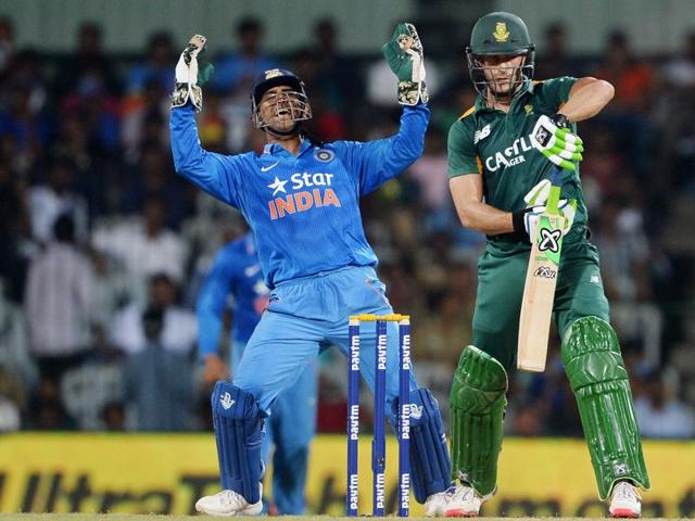 India’s wicket-keeper captain MS Dhoni (L) celebrates after taking the catch that dismissed South African batsman Faf du Plessis. (AFP Photo)