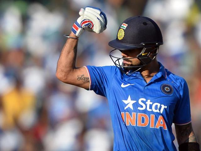 Virat Kohli flexes his muscles in celebration of his hundred. Kohli scored 138 to help India to a total of 299/7. (AFP Photo)