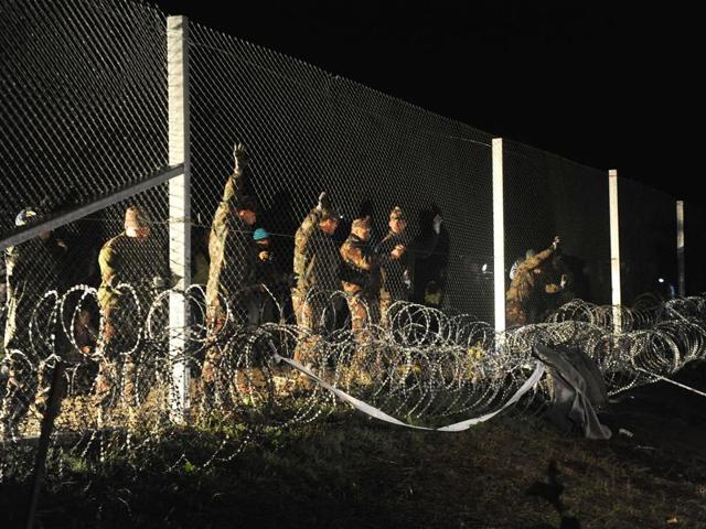 A group of migrants, seen through razor wire, crosses a border from Croatia near the village of Zakany, Hungary. Hungary’s construction of a razor-wire fence along its border with its EU neighbour is the latest sign that the union is unravelling.(AP Photo) A group of migrants, seen through razor wire, crosses a border from Croatia near the village of Zakany, Hungary. Hungary’s construction of a razor-wire fence along its border with its EU neighbour is the latest sign that the union is unravelling.(AP Photo)