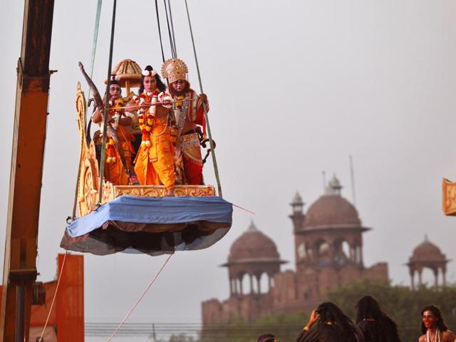 An artist playing the role of Lord Rama during Ramlila shoots an arrow towards the effigy of demon king Ravana on the occasion of Dussehra at Lav Kush Ramlila Committee in New Delhi on Thursday. (Ajay Aggarwal/ Hindustan Times)