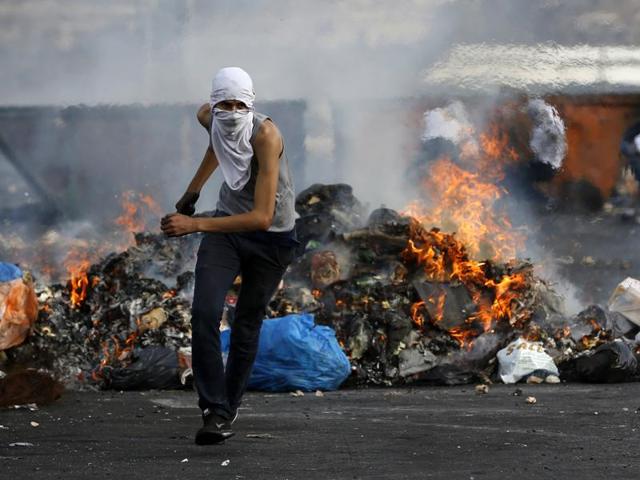 A Palestinian protester clashes with Israeli security forces (unseen) in the West Bank town of Al-Bireh. (AFP) A Palestinian protester clashes with Israeli security forces (unseen) in the West Bank town of Al-Bireh. (AFP)