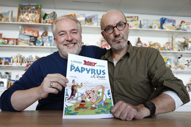 Author Jean-Yves Ferri (R) and illustrator Didier Conrad (L) pose with a print of the cover of their new comic book Le Papyrus de Cesar (Asterix and the Missing Scroll) in Vanves, Southern Paris, France, October 13, 2015. (REUTERS) Author Jean-Yves Ferri (R) and illustrator Didier Conrad (L) pose with a print of the cover of their new comic book Le Papyrus de Cesar (Asterix and the Missing Scroll) in Vanves, Southern Paris, France, October 13, 2015. (REUTERS)