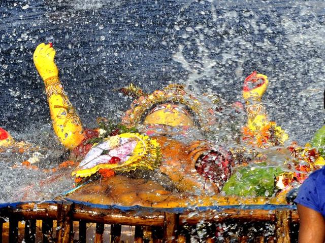 Devotees immerse an idol of the goddess Durga in Yamuna at Kalindi kunj in New Delhi. (Mohd Zakir/Hindustan Times)