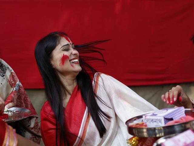 Married Bengali women play “Sindoor Khela”, smearing vermillion on each other, during the final day of Durga Puja festivities in New Delhi. (Ravi Choudhary/Hindustan Times)