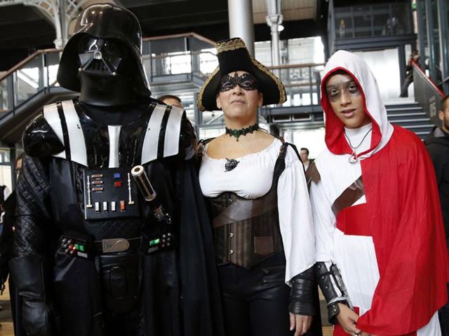 People dressed up as Star Wars character Darth Vader (left) and video game Assassin’s Creed character (right) pose during the first Comic Con convention in Paris. (AFP)
