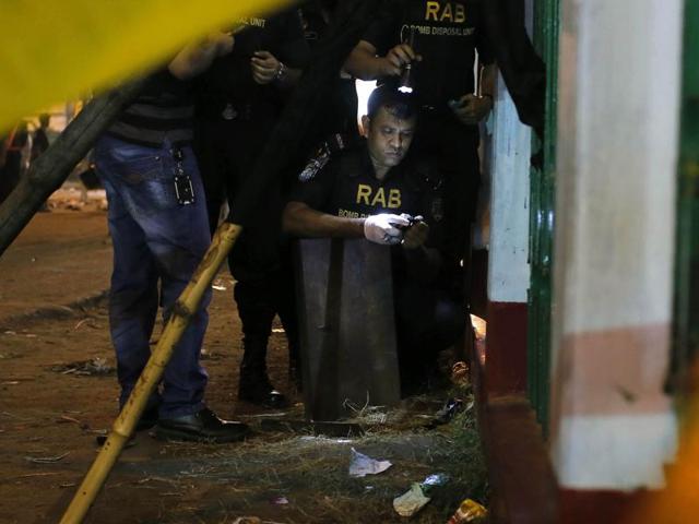 Bangladeshi bomb disposal unit from Rapid Action Battalion (RAB) defuse an unexploded bomb at the site of an explosion in Dhaka. (AP) Bangladeshi bomb disposal unit from Rapid Action Battalion (RAB) defuse an unexploded bomb at the site of an explosion in Dhaka. (AP)