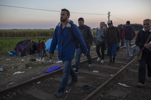 In this Saturday, Sept. 12, 2015 photo, Mohammed al-Haj, front left, and his friends walk on the railway tracks near the Serbian village of Horgos. (AP Photo) In this Saturday, Sept. 12, 2015 photo, Mohammed al-Haj, front left, and his friends walk on the railway tracks near the Serbian village of Horgos. (AP Photo)