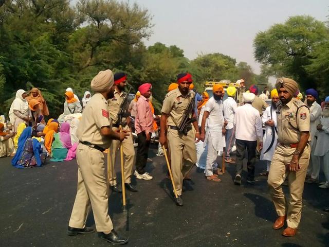 Police preventing protesters from going up to Gurdwara Sulisar Sahib at Kotdharmu village in Mansa district, where deputy chief minister Sukhbir Singh Badal was to attend the bhog ceremony of an ‘akhand paath’.(HT Photo)