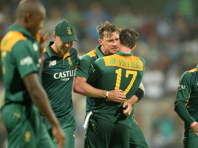 Dale Steyn, centre, gets a hug from his captain AB de Villiers after taking the wicket of Ajinkya Rahane. (AFP Photo)
