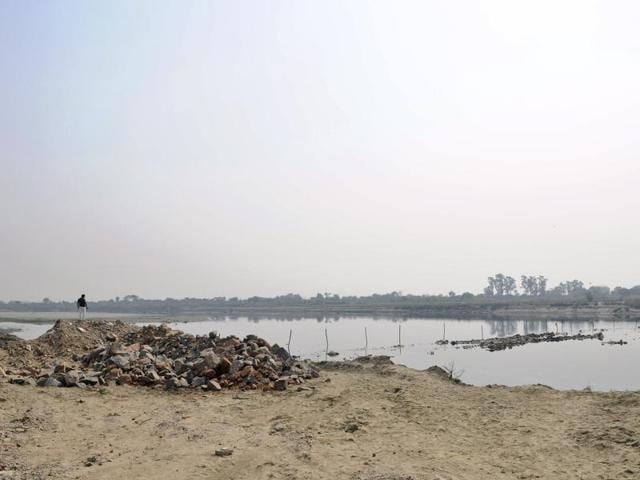 In the last 15 years that saw Noida develop into a realty hub, this is the first time that a private individual has tried to build two bridges with cemented pipes, sand bags and excavator.(Burhaan Kinu/HT Photo)