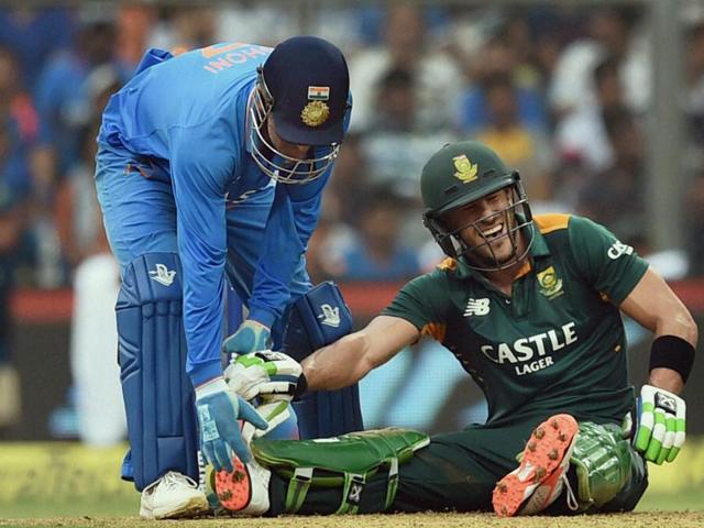 Indian captain MS Dhoni helps Faf du Plessis after the South African suffered from cramps during his knock of 133 retired hurt. (PTI Photo)