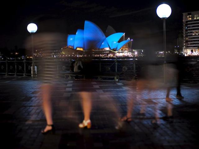 A group of women visiting Sydney's waterfront walk past the Sydney Opera House illuminated in blue. Around 200 iconic monuments will be lit up in blue, the official colour of the United Nations, as part of a global campaign to commemorate its 70th anniversary. (REUTERS Photo) A group of women visiting Sydney's waterfront walk past the Sydney Opera House illuminated in blue. Around 200 iconic monuments will be lit up in blue, the official colour of the United Nations, as part of a global campaign to commemorate its 70th anniversary. (REUTERS Photo)