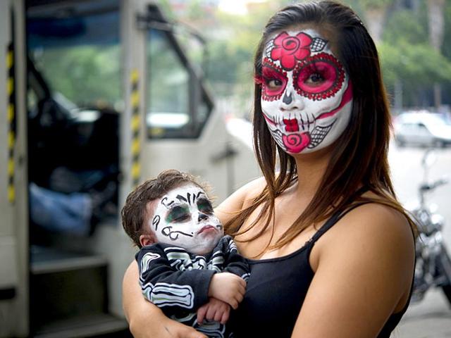 A woman and her baby painted as Catrinas pose before taking part in the Procession of the Catrinas in Mexico City. (AFP)