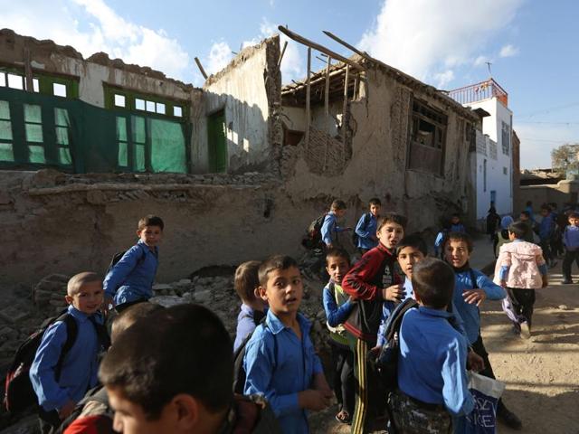 Afghan school boys tour the neighborhood to look at damaged houses. At least 70 people, including 12 Afghan girls, were killed in the earthquake. (AP)