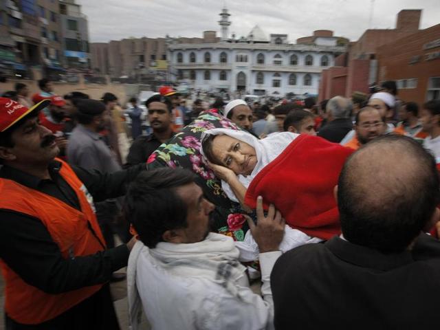 People rush an injured woman to a local hospital in Peshawar, Pakistan. (AP)