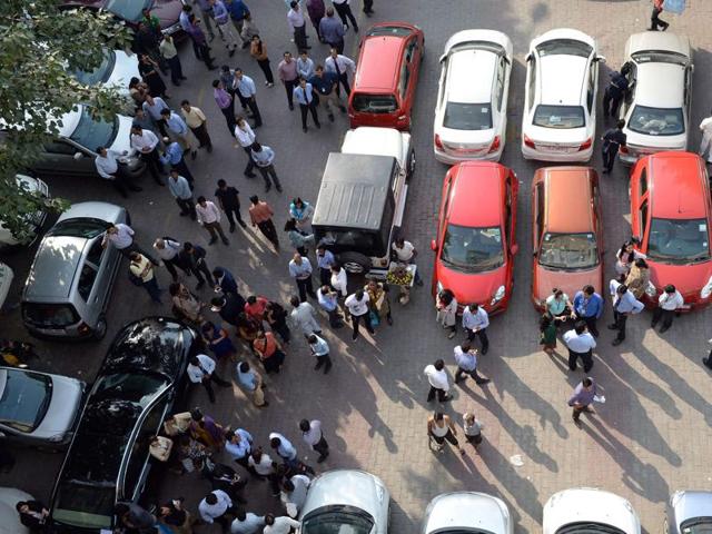 Office workers stand in an open area in a carpark following an earthquake in New Delhi. A strong earthquake lasting almost a minute was felt in New Delhi on October 26, with buildings shaking in the centre of the Indian capital. (AFP)