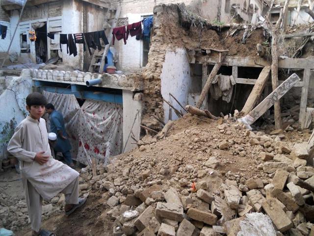 A Pakistani boy stands on the rubble of houses after an earthquake in Kohat. (AFP)