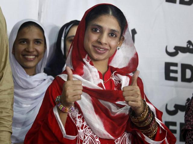 Geeta greets media with a thumbs up prior to her departure from the international airport in Karachi, Pakistan. (AP Photo)