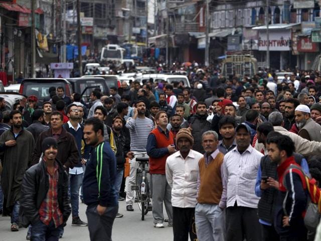 People stand on a road after vacating buildings following an earthquake in Srinagar. (REUTERS)