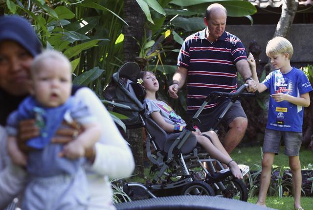 Mark Hooper plays with his daughter, Charley, and son Zak, right, as his youngest son Cody, left, is carried by a nanny. (AP) Mark Hooper plays with his daughter, Charley, and son Zak, right, as his youngest son Cody, left, is carried by a nanny. (AP)