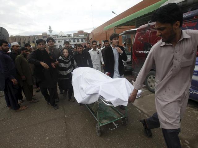 A man wheels a body of a woman, who died in an earthquake, at the Lady Reading hospital, Peshawar, Pakistan. (REUTERS)